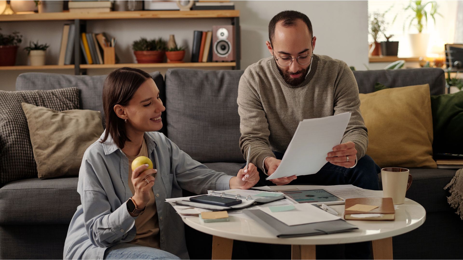 Newlywed couple reviewing financial and legal documents together at a table, symbolizing early estate planning and shared future goals.