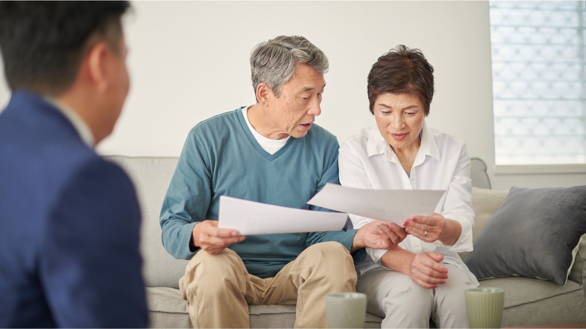 An elderly couple reviewing estate planning documents with their attorney, symbolizing year-end Estate Planning Madison.