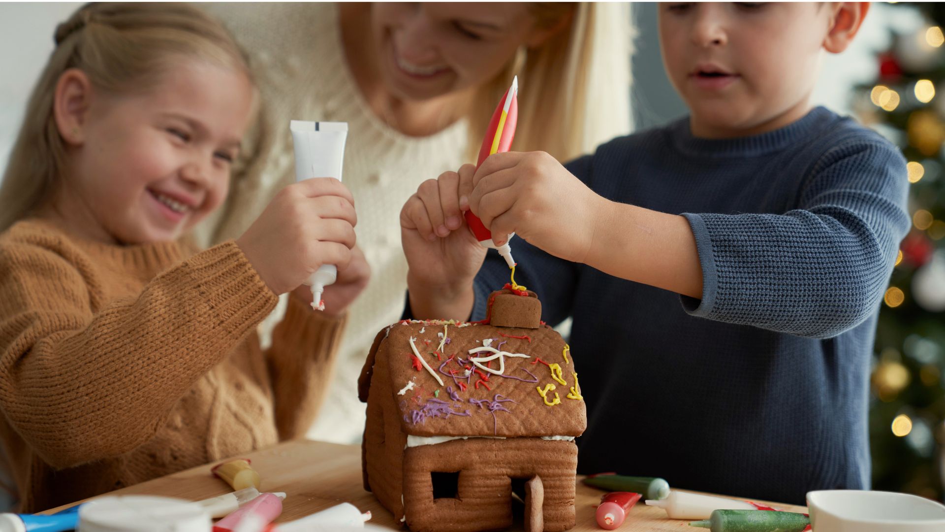 Family decorating a gingerbread house together, showcasing holiday bonding and shared seasonal traditions.