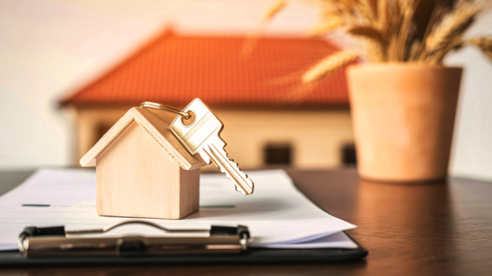 Miniature house with property documents and a house key, representing legal considerations when property ownership changes.